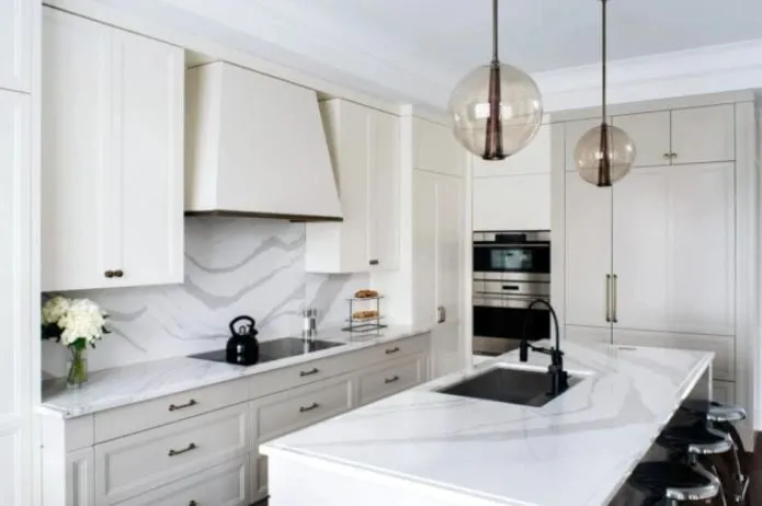 Modern white kitchen with marble-look quartz countertops and black fixtures
