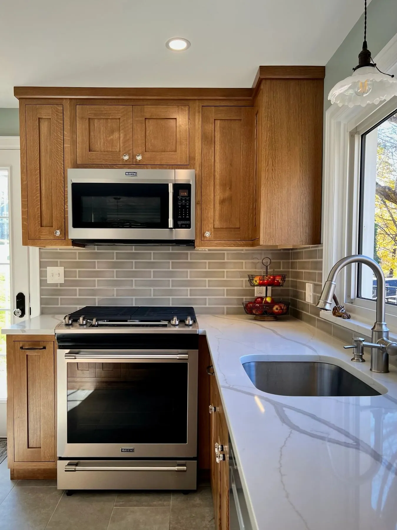 Range wall with white oak cabinets and stainless microwave hood in Deep River CT