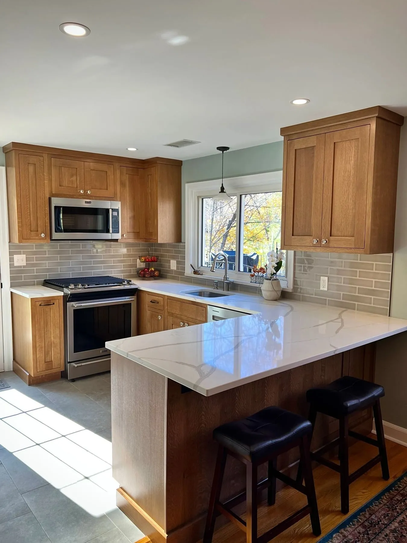 White oak cabinets with peninsula seating and marble-look quartz in Deep River CT