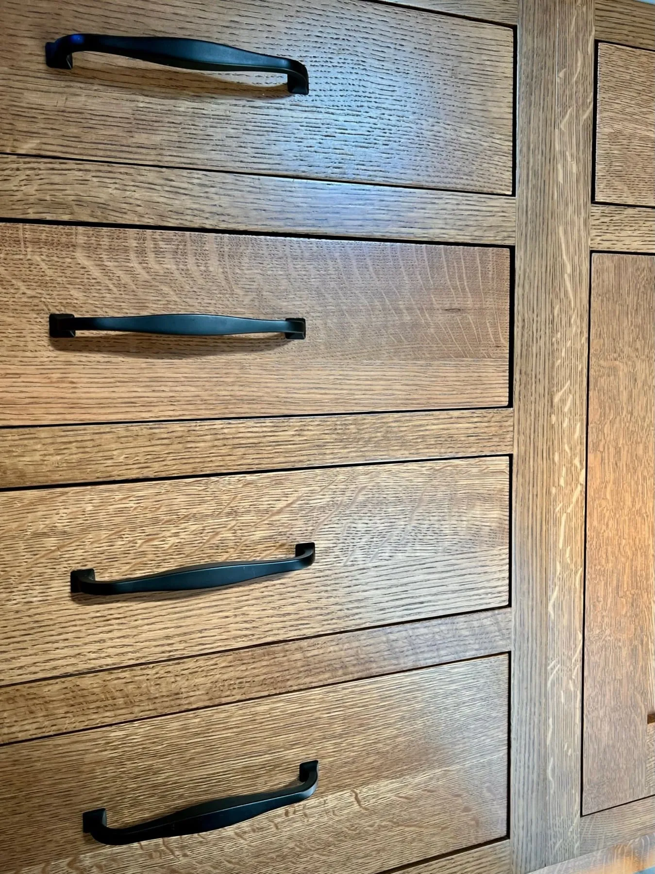 Close-up of quarter-sawn white oak drawer fronts with black bar pulls