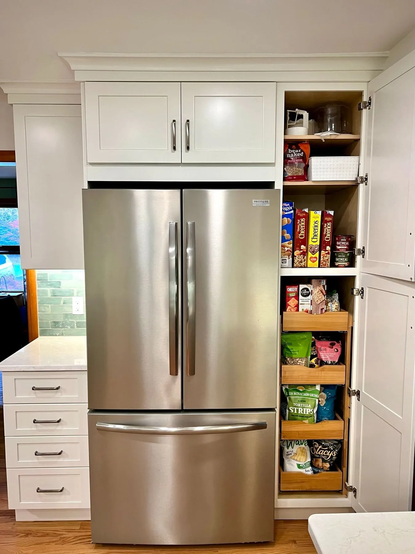 Full-height pantry cabinet beside a stainless French-door refrigerator in Guilford CT