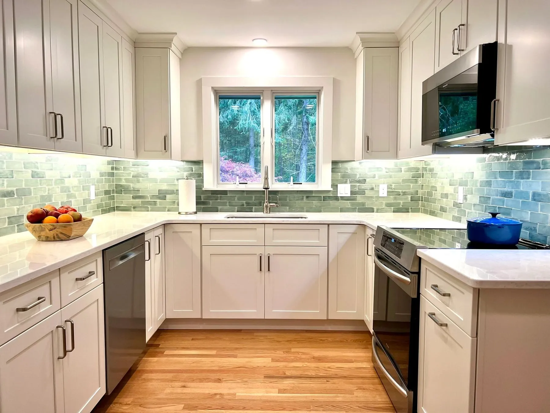 White Fabuwood Galaxy kitchen in Guilford CT with sage green tile backsplash and window over the sink