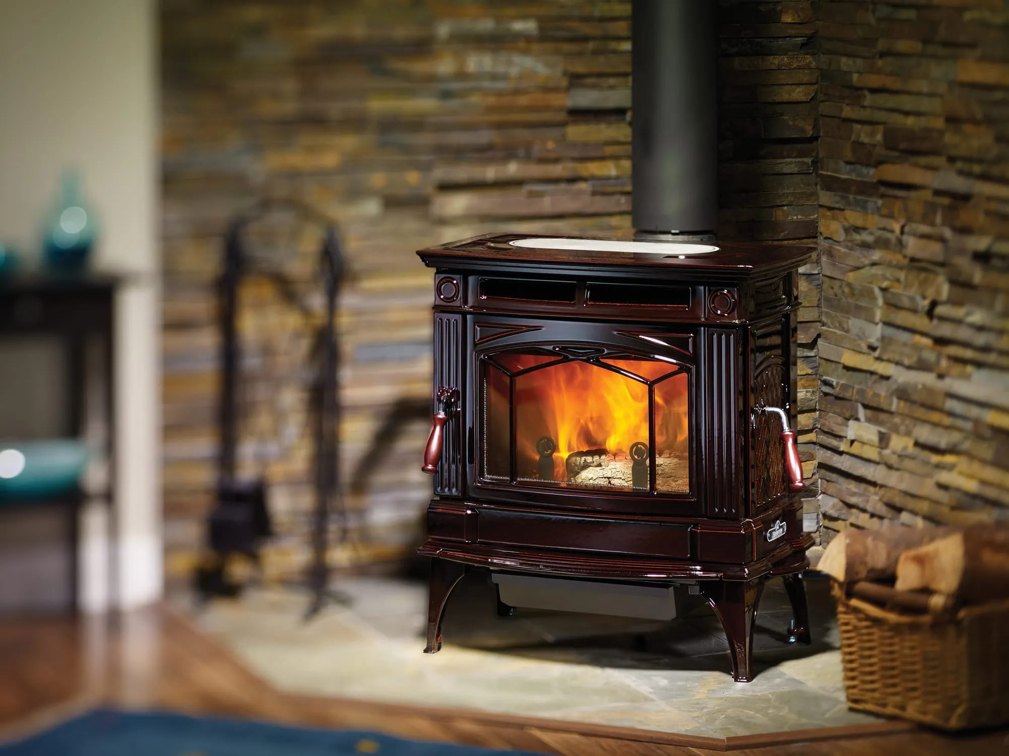 Regency H300 cast iron wood stove burning beside a stone wall
