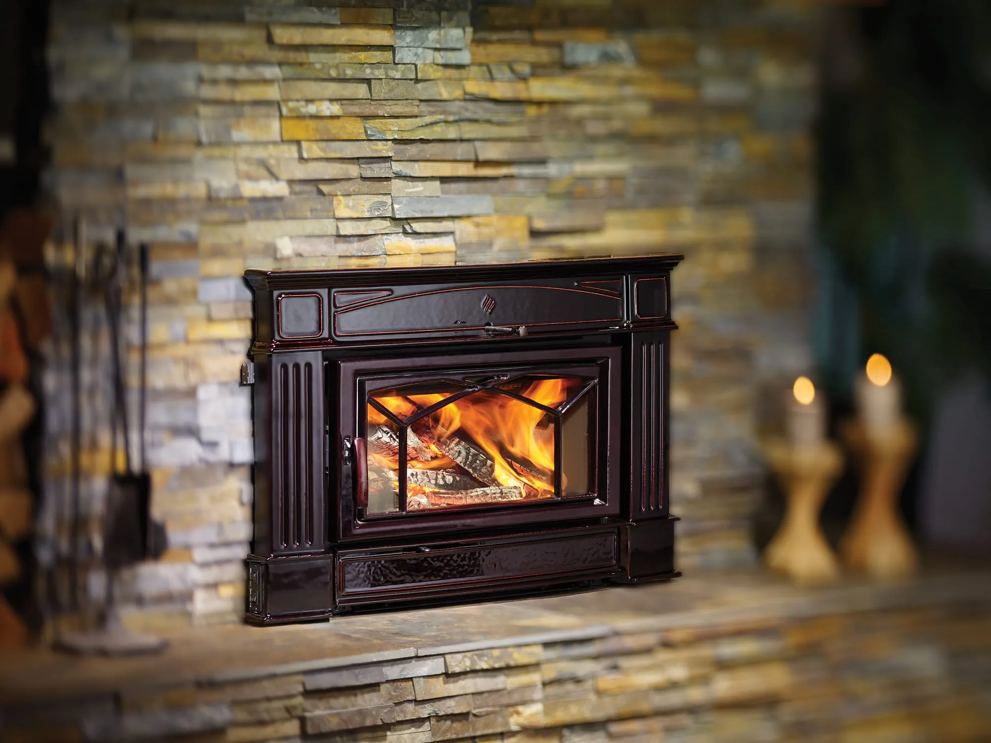 Regency HI400 wood fireplace insert burning in a stacked stone fireplace